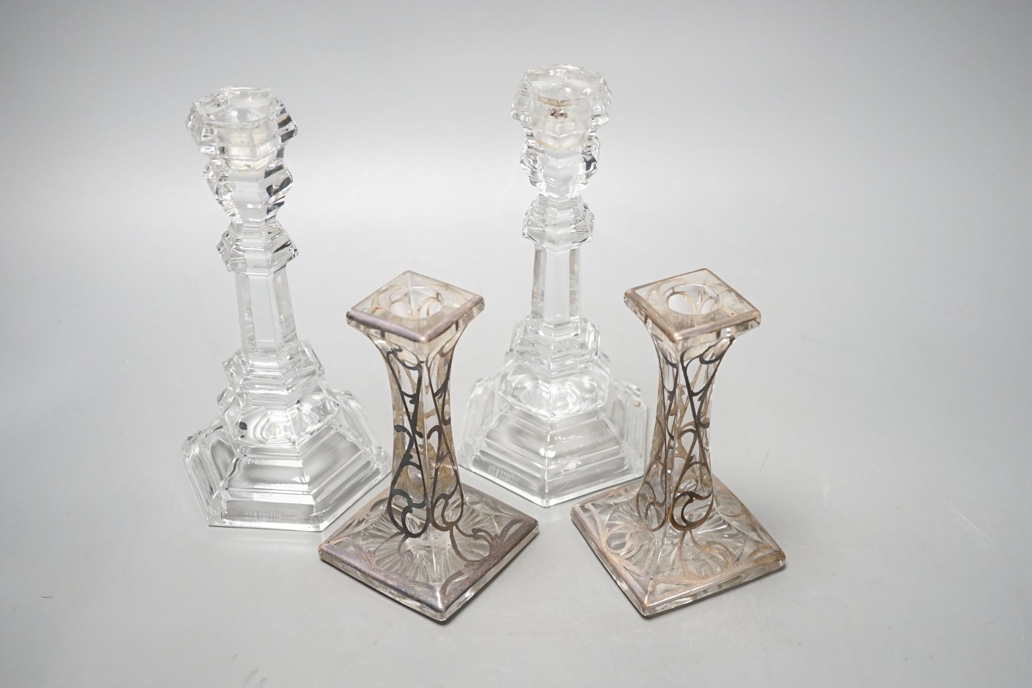 A pair of Tiffany & Co. glass candlesticks and a pair of silver overlaid glass candlesticks 20cm